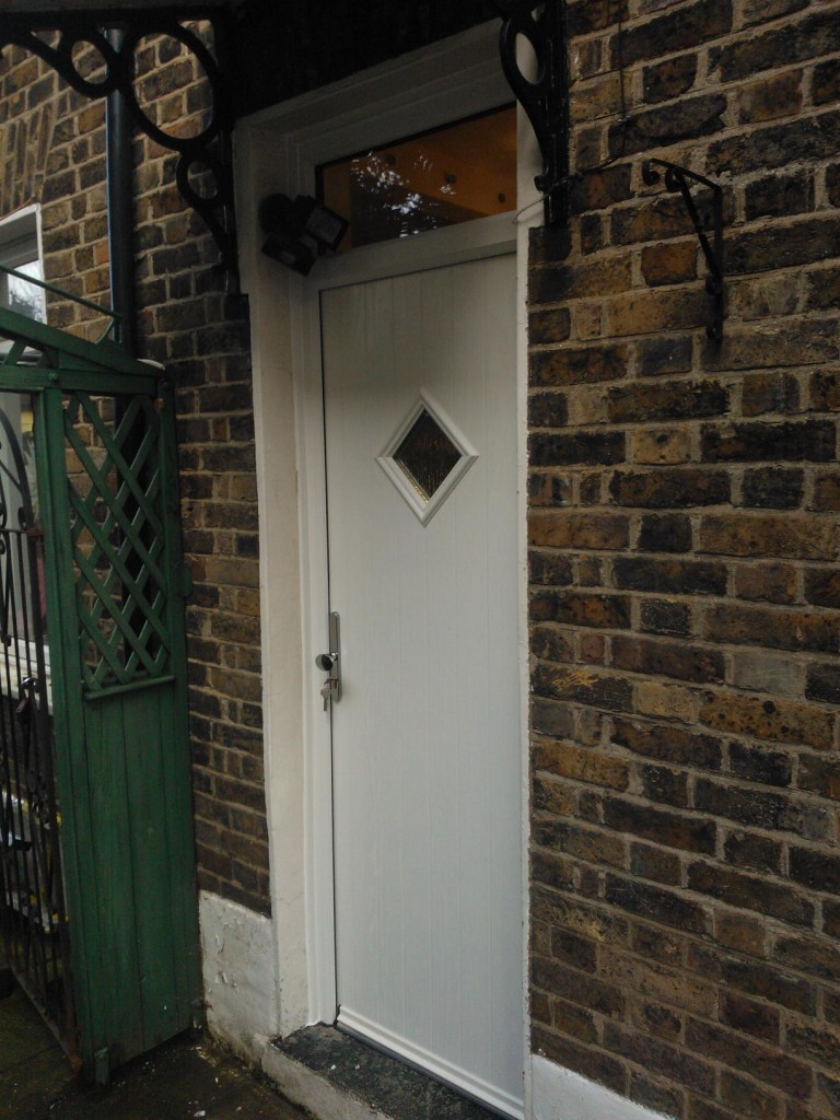 The Solidor Flint 1 composite door brings rustic charm with its vertical plank design and classic single diamond window